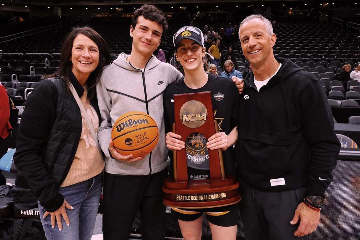 Caitlin Clark posing with her parents Brent Clark and Anne Nizzi-Clark after receiving an award